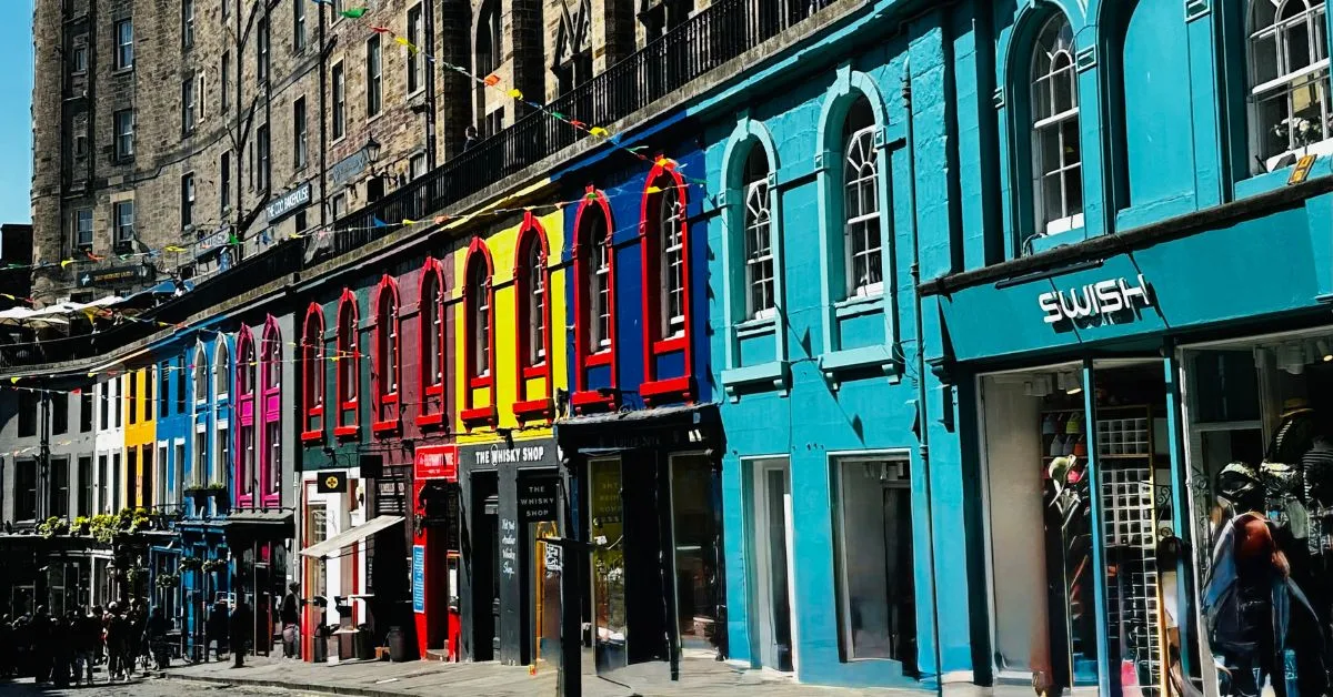 Curved cobbled street with multi colored buildings with arched windows, in Edinburgh.