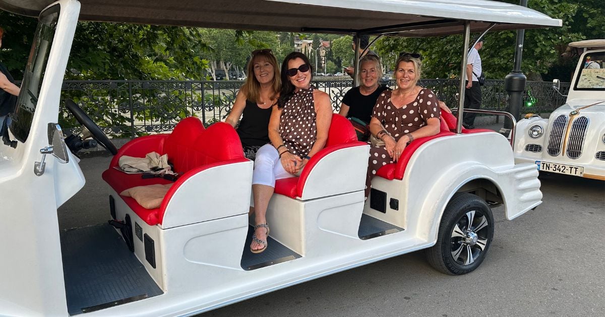 Tourist train cart carrying passengers through Tbilisi streets