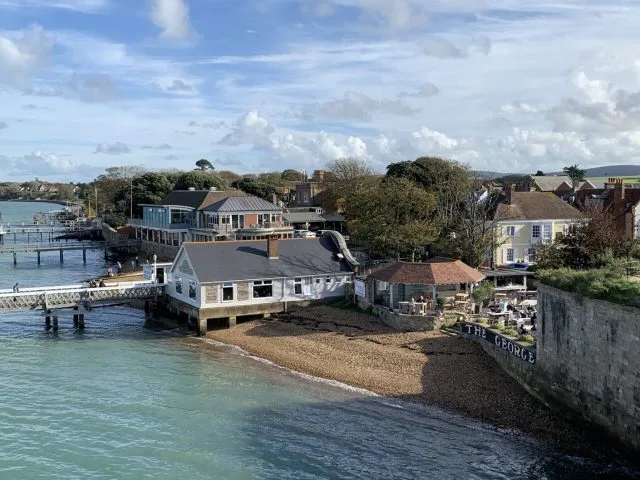 Coastal scene of houses which have long wooden docks out over the water.