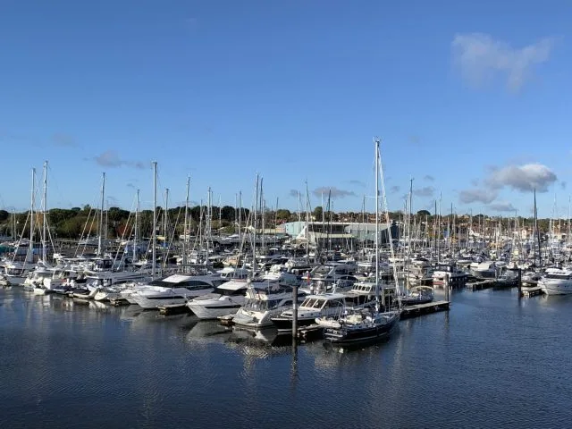 Small sail boats are tied up in a local marina in Lymington England.