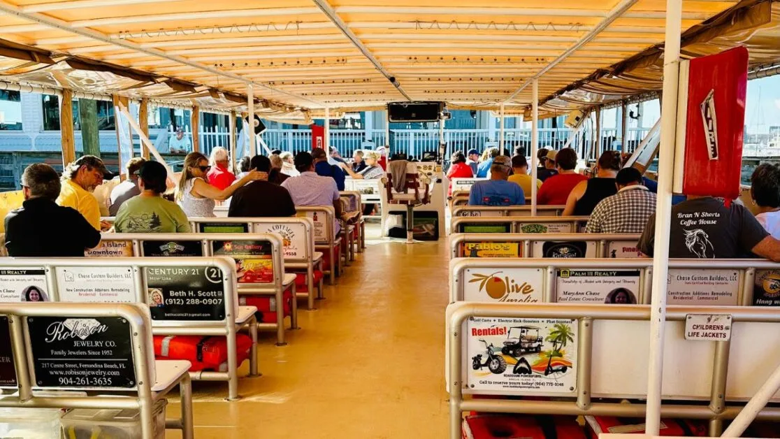 Passengers sitting on covered deck of a tour boat.