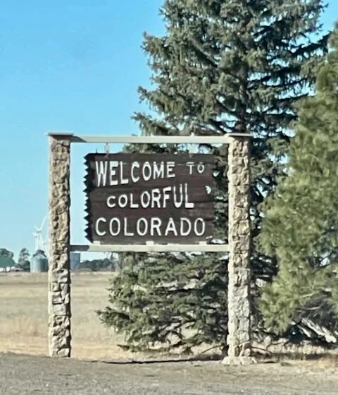 A sign with the words 'Welcome to Colorful Colorado' as you enter the state from Kansas.