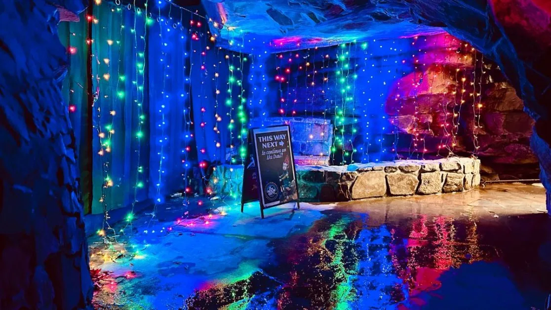 Lights of different colors hanging inside a cave.