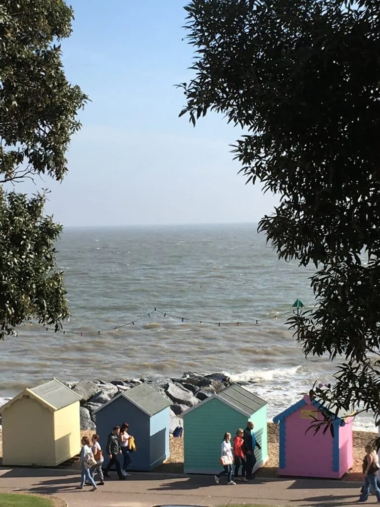Bathing huts you can rent at Felixstowe beach each is a bright colour Yellow, Pink, green or blue