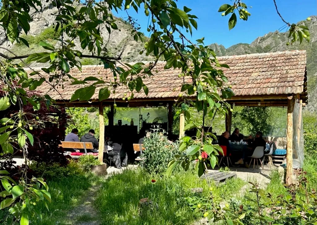A covered open restaurant in Ateni Valley central Georgia. People are eating in the shade.