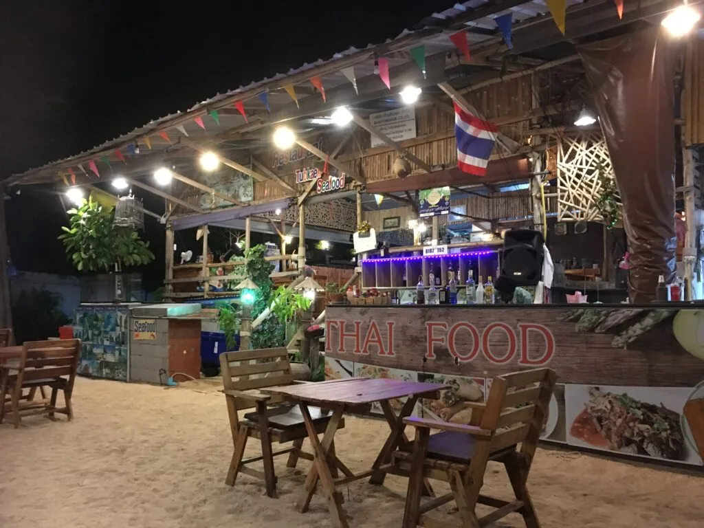 Evening dining on the beachfront with tables set for dinner.