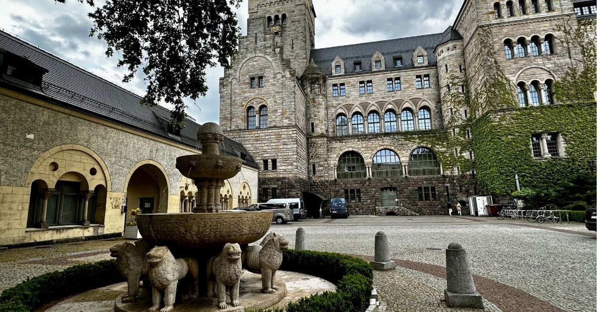 Courtyard Fountain of Imperial Palace in Poznan and behind it are old stables and the tower of part of the Imperial Palace.