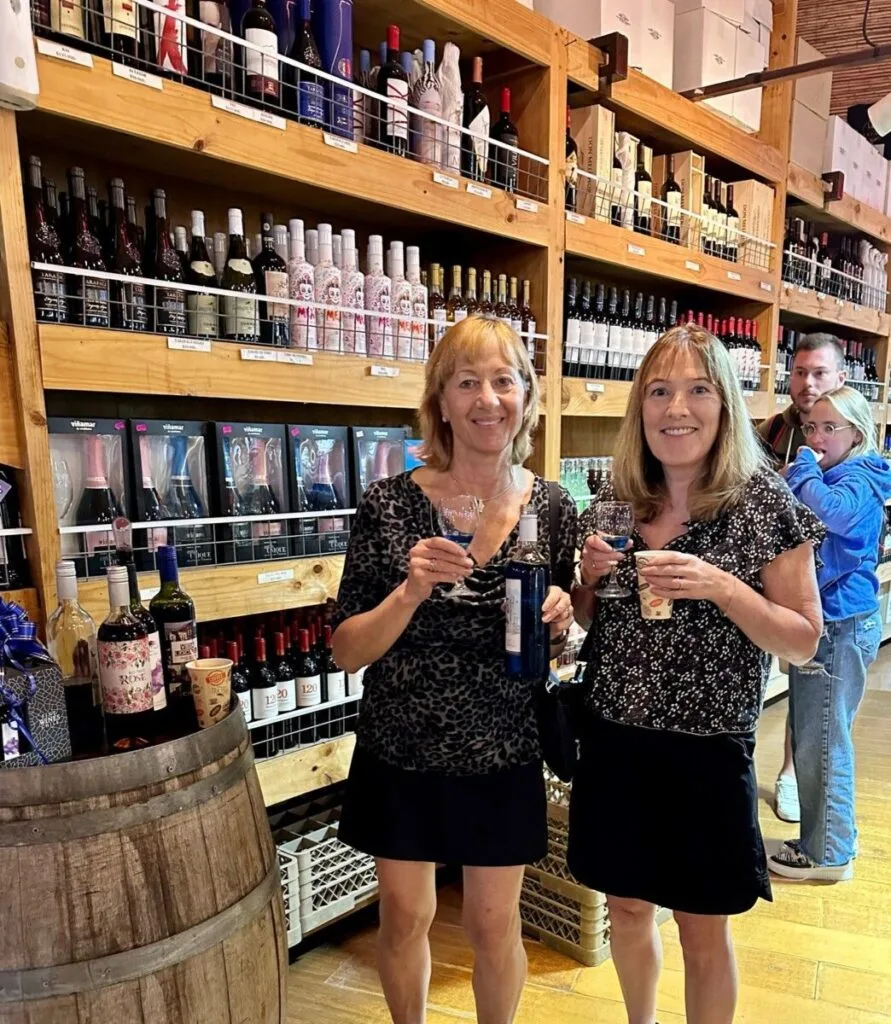 Women tourists in Chile tasting coffee and wine at a road side store.