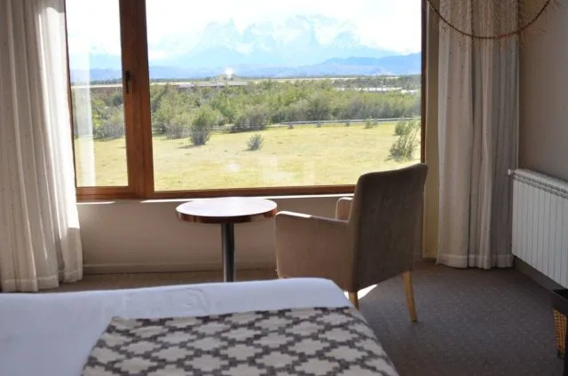 Hotel Room Chile with views out to Patagonian Mountains and grass area in the forefront.