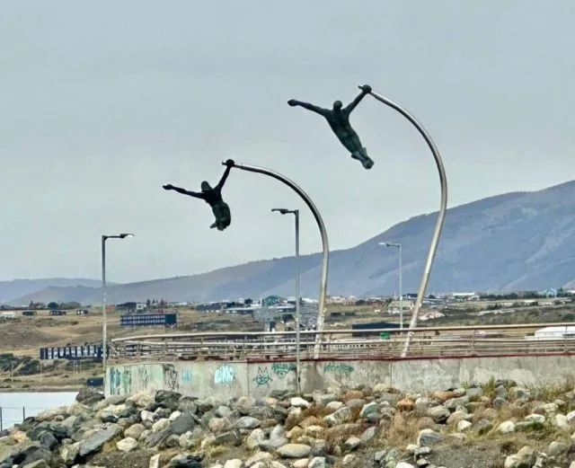 Art up in the air. Figures are hanging from poles similar to how a pole vaulter would look in the air.