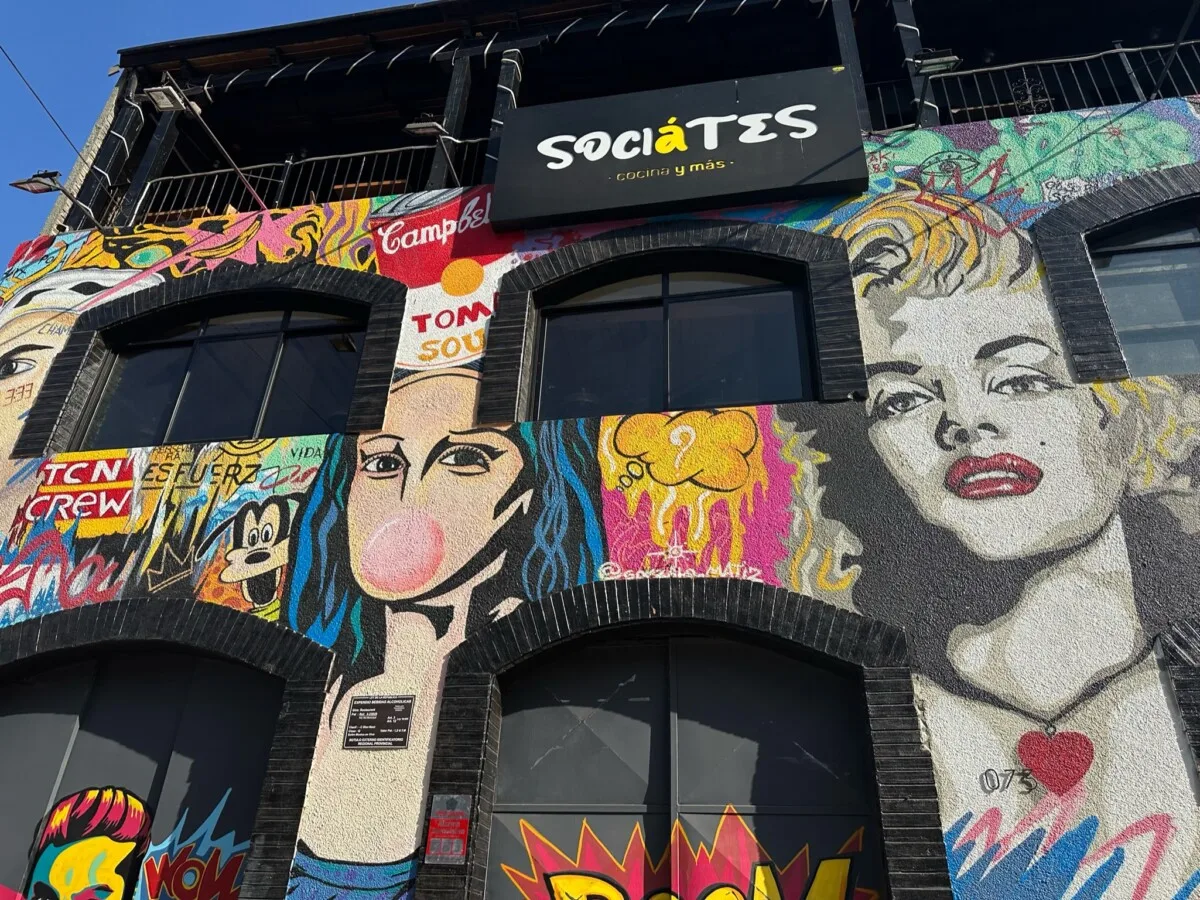 Street Art depicting faces fill the front of a multi-story building restaurant in Santiago, Chile.