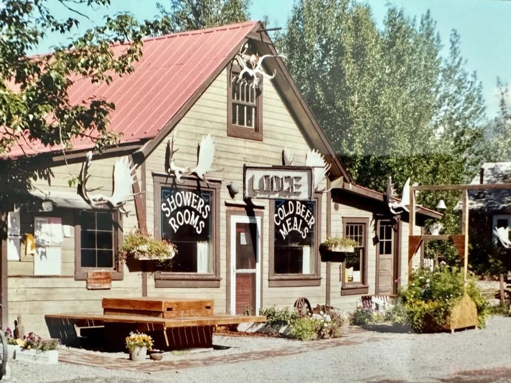 A lodge in McCarthy a remote village in Alaska with signage for lodging and beer. Antlers horns decorate the outside wall above the entrance.