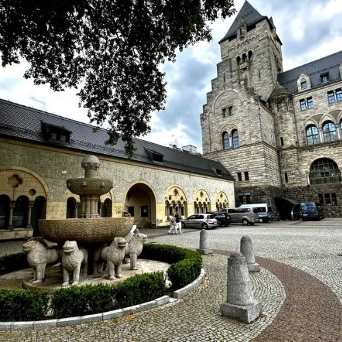 Courtyard Fountain of Imperial Palace in Poznan and behind it are old stables and the tower of part of the Imperial Palace.