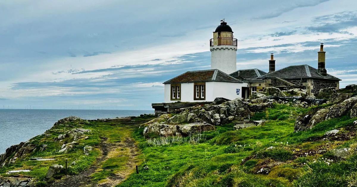 An original lighthouse, whitewashed set on rocky outreach of Isle of May Scotland.