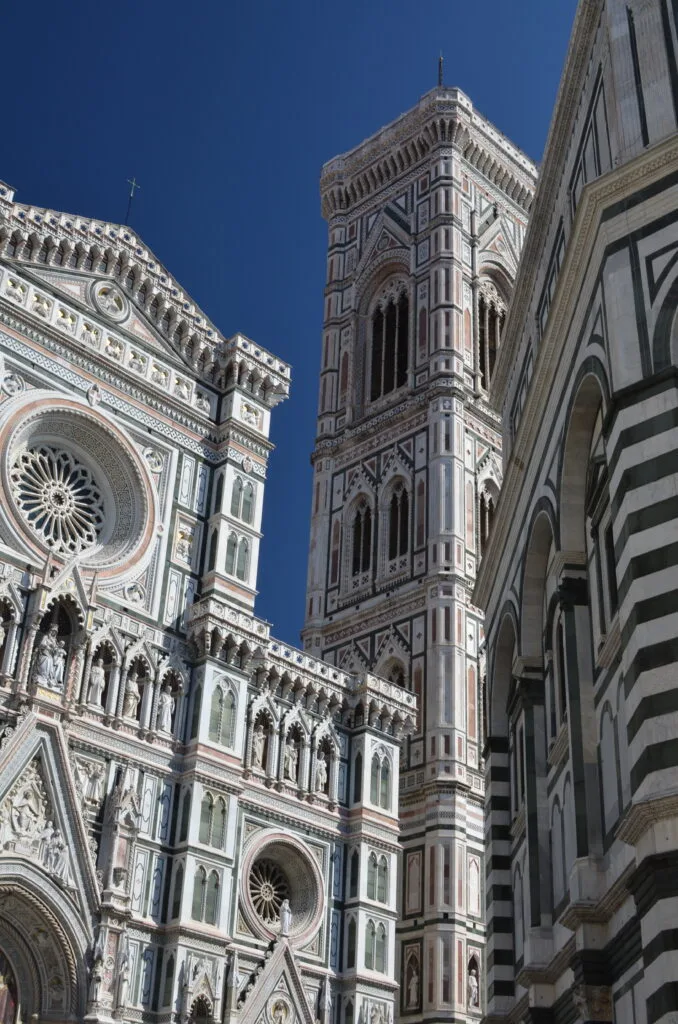 A Cathedral within the ground of the Leaning Tower of Pisa is ornately decorated in black and white design.