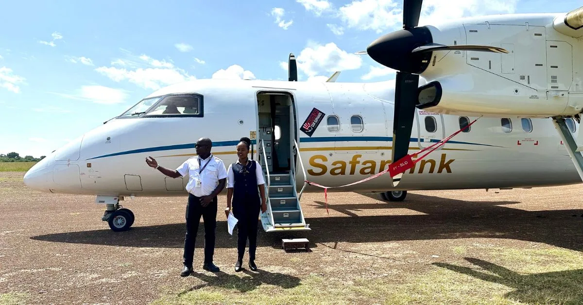 Turboprop aircraft at Mara North Airstrip Maasai Mara, Kenya. A pilot and flight attendant are welcoming guests.