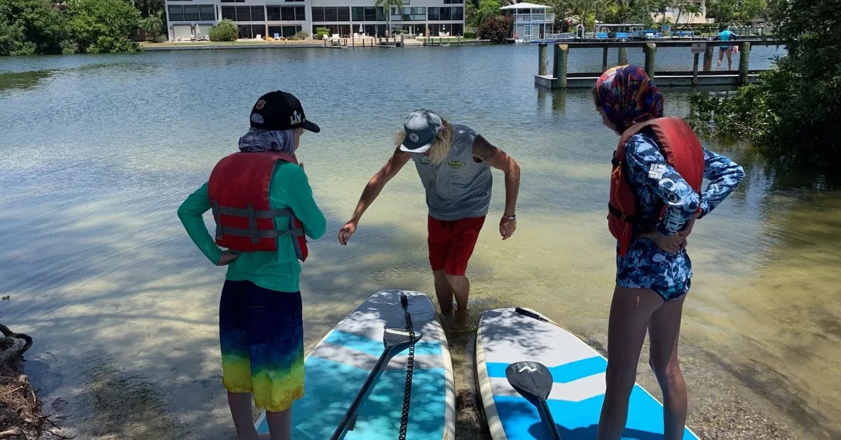 Kids getting a SUP lesson at Turtle Beach
