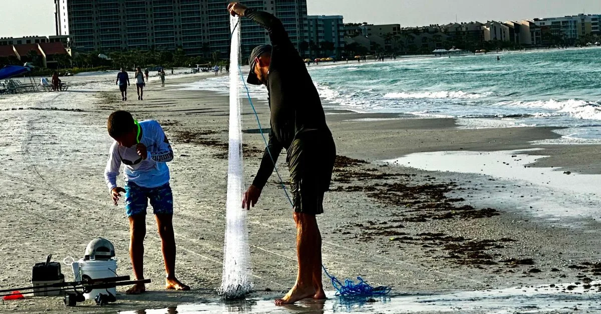 Father and son are setting up a fishing net and baiting lines on a beach at Siesta Key.