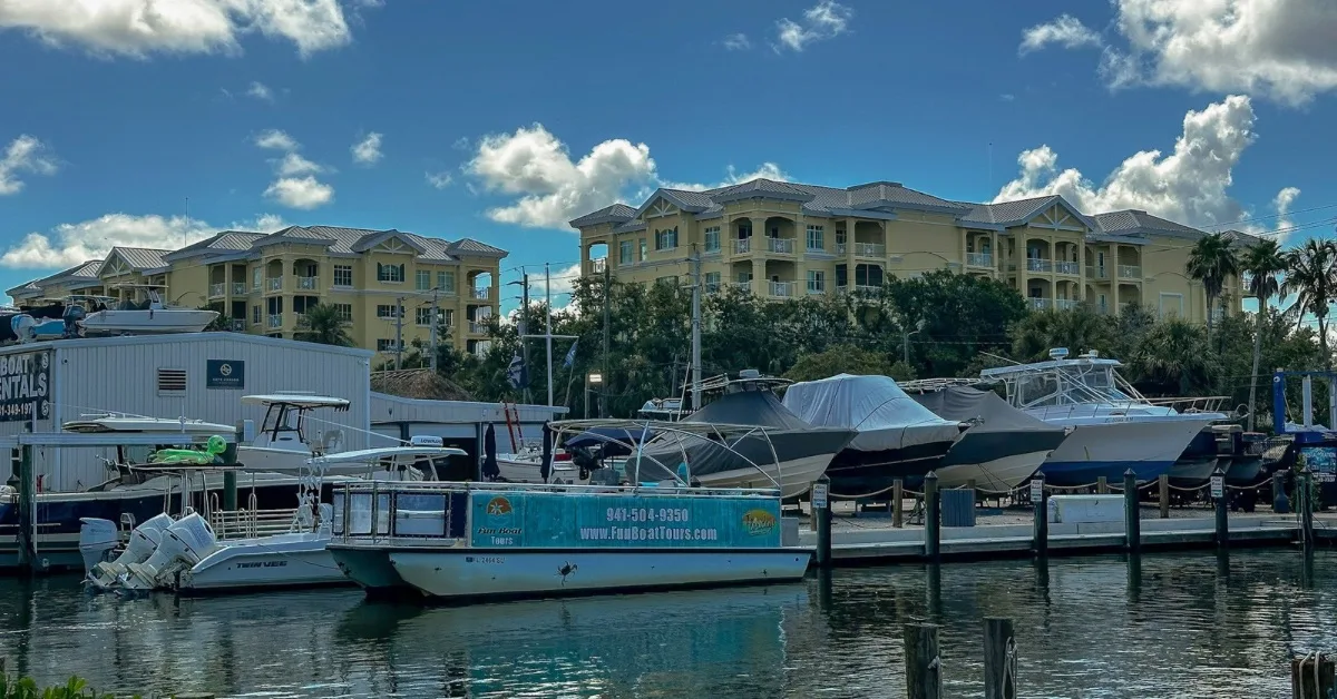 Boat moored at a marina with multi-story condos behind.