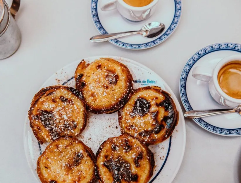 A plate of custard tarts called Pastels de Nata that originate from Lisbon Portugal and are a popular breakfast choice.