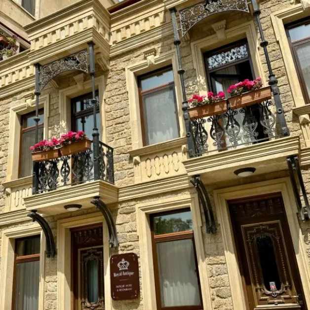 Front of the Royal Antique Hotel in Baku with wrought iron balconies full of flower boxes.