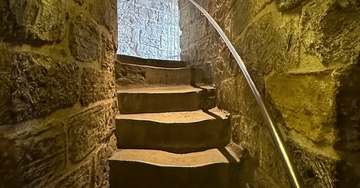 Circular stone staircase inside Maiden Tower Baku with handrail.