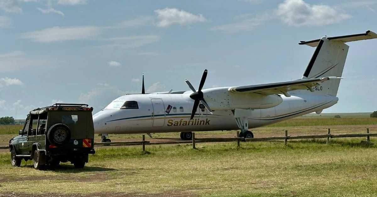 Plane at landing airstrip with LandRover waiting for guests to disembark.