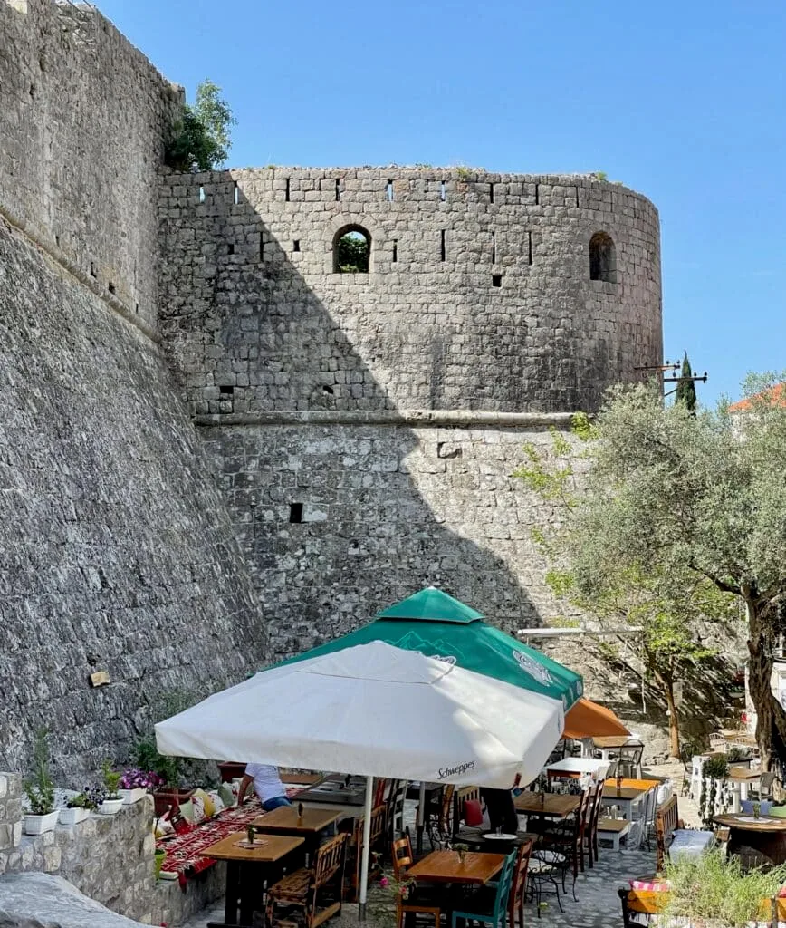 Old Bar in Montenegro with city stone fortress gives shade to street cafes.