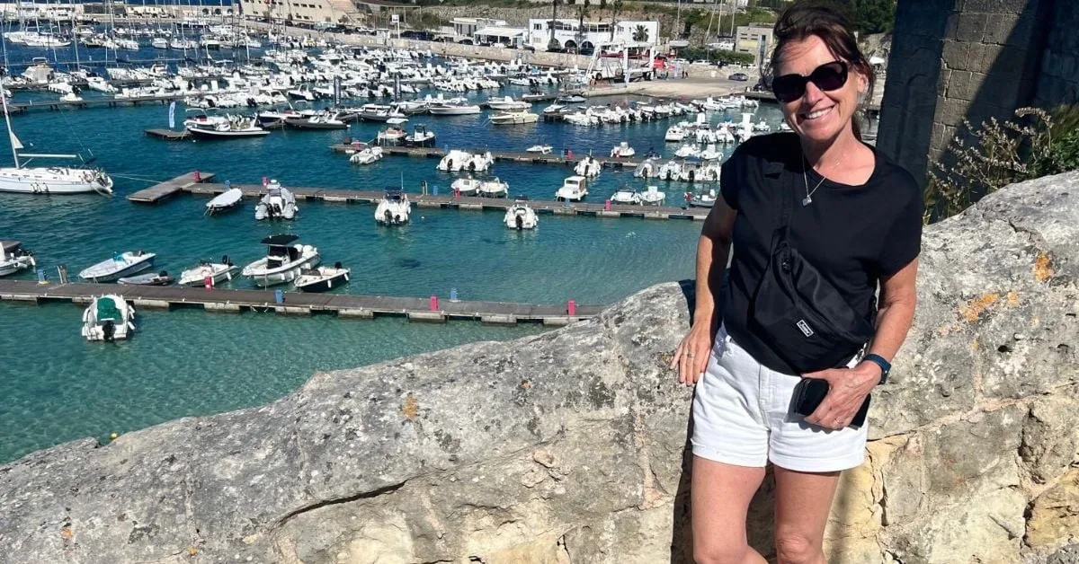 Harbour with colourful boats in Otranto, Puglia — woman enjoying the waterfront
