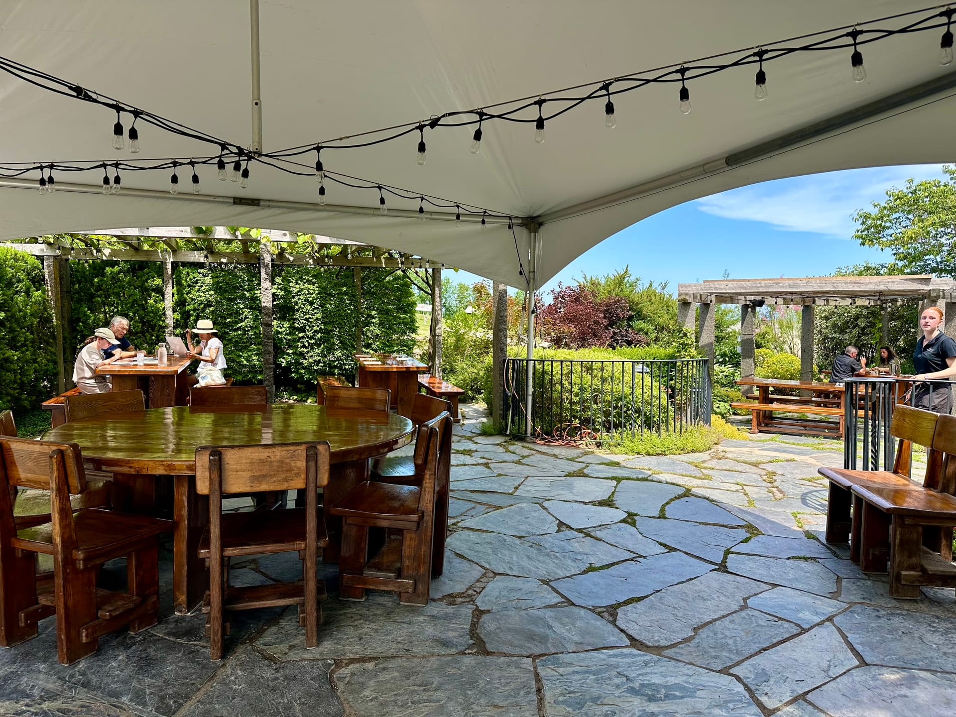 Tree-lined outdoor dining patio at Grand Pre winery