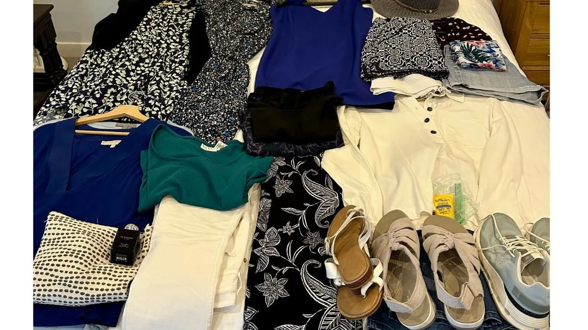 Clothes, shoes and travel items laid out ready to pack into a suitcase