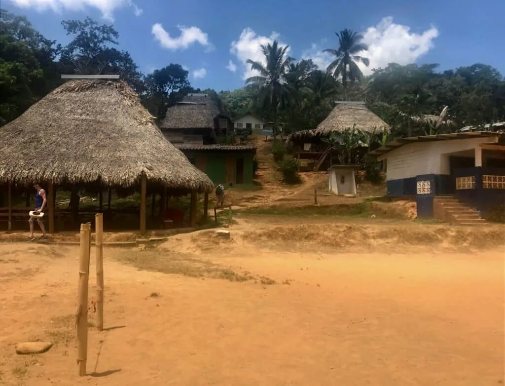 Embera village of round homes shows earthen floored, straw thatched homes.