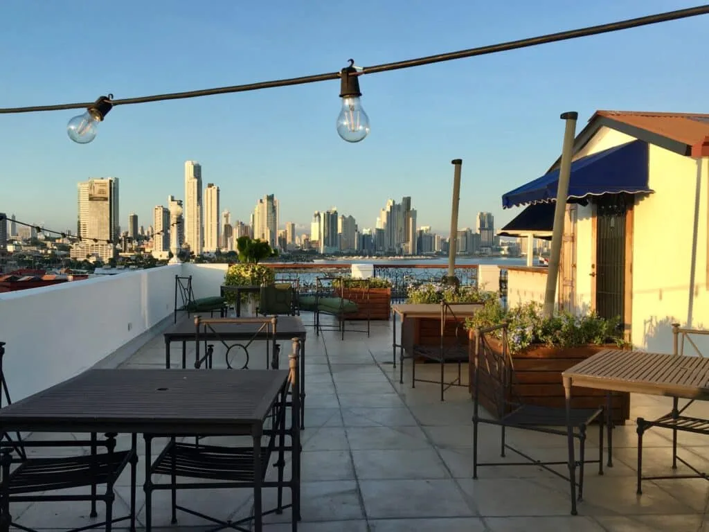 Roof terrace in Panama City. Shadows fall onto the rooftop terrace as sun starts to set. A string of bulbs overhead will illuminate once darkness falls.