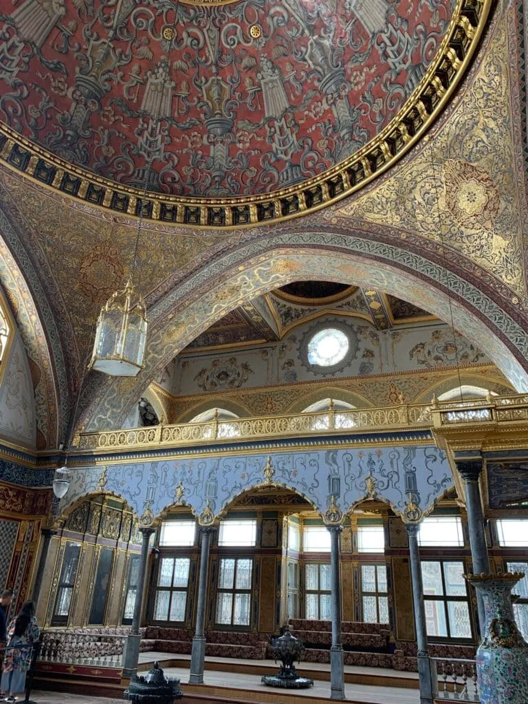A ceiling highly decorated in red and gold inside Topaki Palace Istanbul.