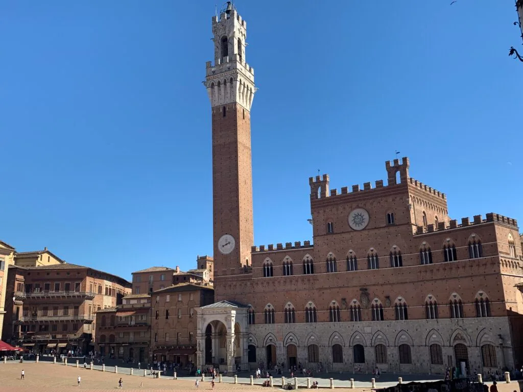 Siena on our tour of italy itinerary has an enormous red brick style square with a high clock tower. Races are held in the square annually.