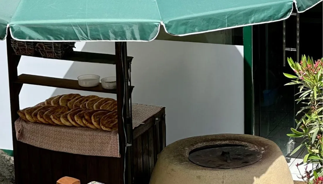 Freshly baked loafs sit on a counter next to a wood fired stone oven in Baku, Azerbaijan.