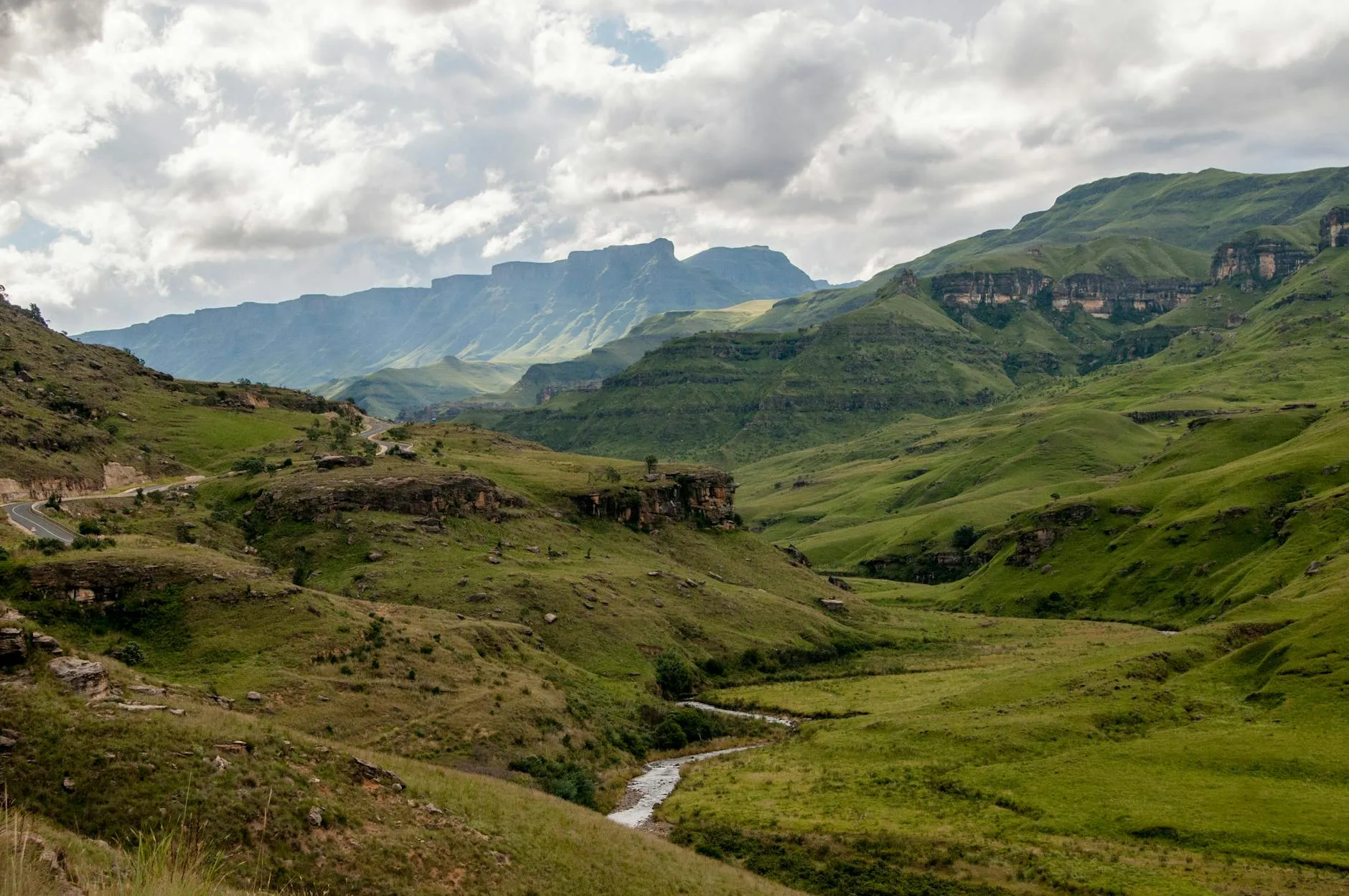 Lush green landscape of the Drakensberg mountains with a winding river, South Africa