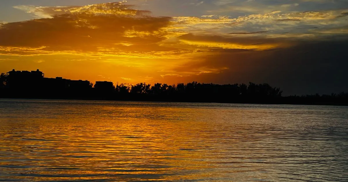 Sunset casting orange hue over the coastline and waters of Sarasota Bay.