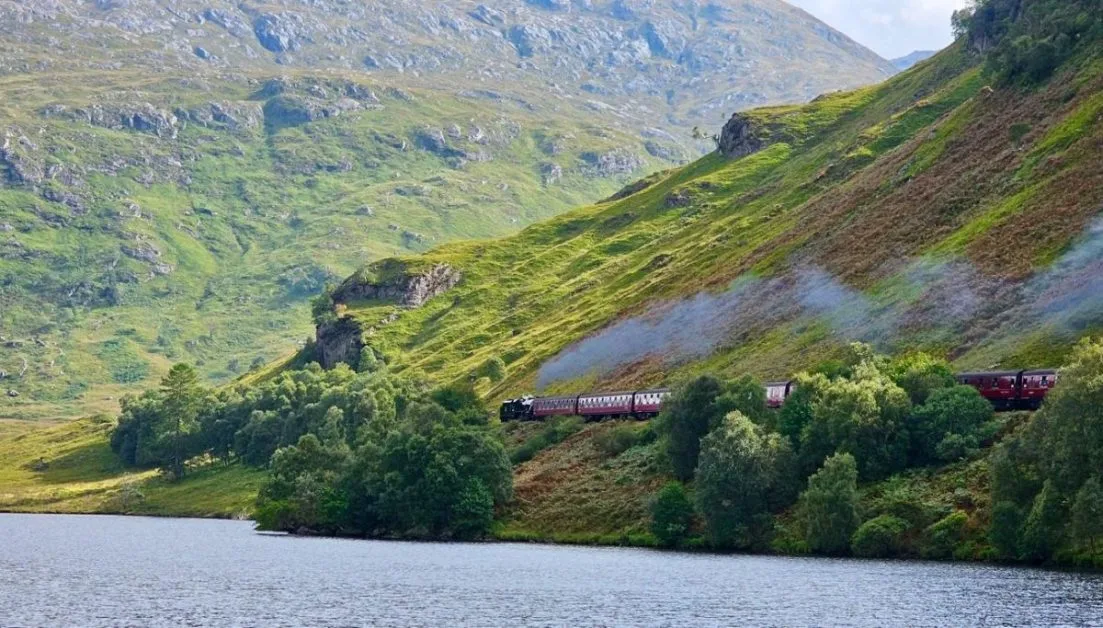 Scotland "Harry Potter' Jacobite Express Train. Puffs of steam fill the air as it climbs through the highlands.