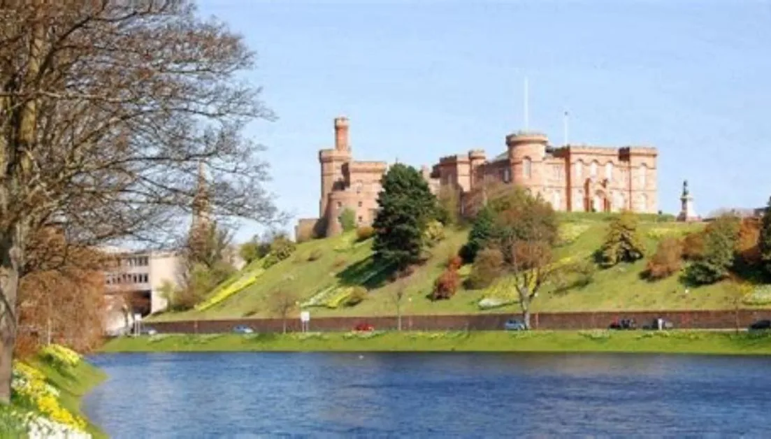 A castle is perched on a hill next to a river in the Scottish town of Inverness.
