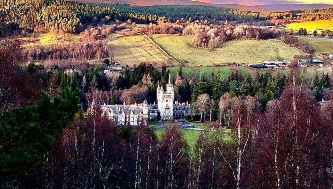Balmoral castle, home to the British Royal Family surrounded by fields and woodlands.
