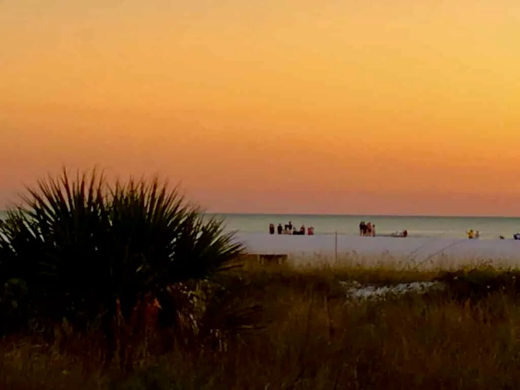 Sun has set and the sky is an orange glow on Siesta Key Beach Sarasota.