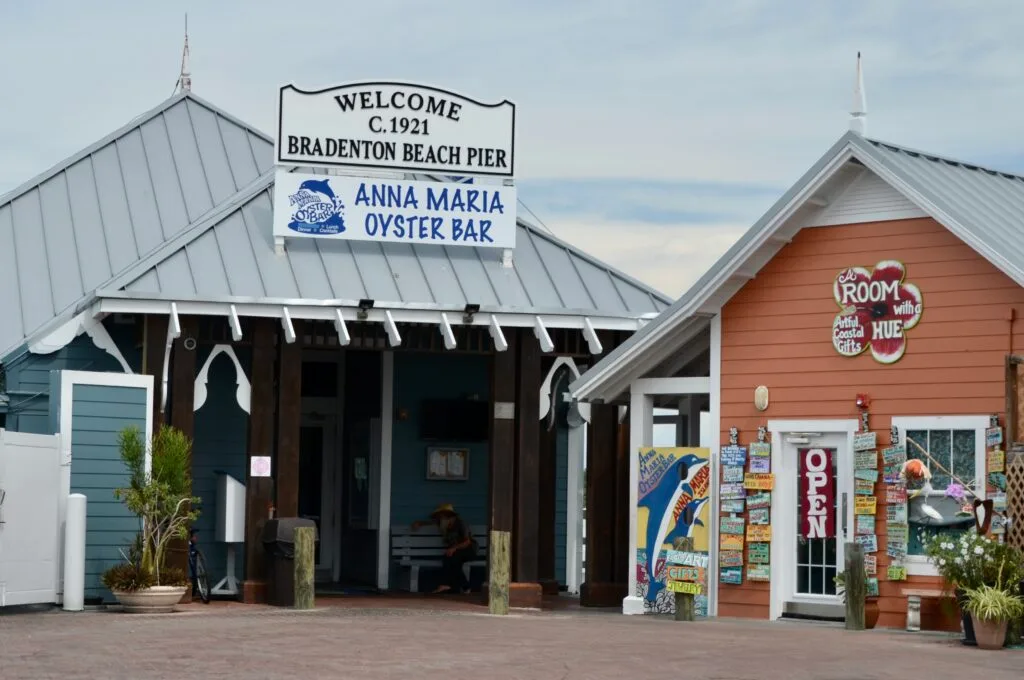 A small metal roofed building is an oyster bar adjacent to a pier in Cortez, Florida.