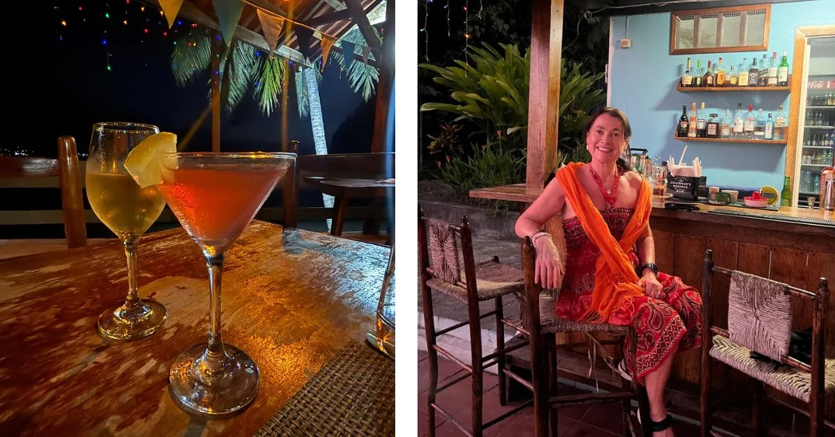 two cocktails on a table and a woman sitting at a beachside bar in the evening