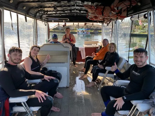 Tourists are on board a small boat that is searching on Crystal River Florida for Manatees.