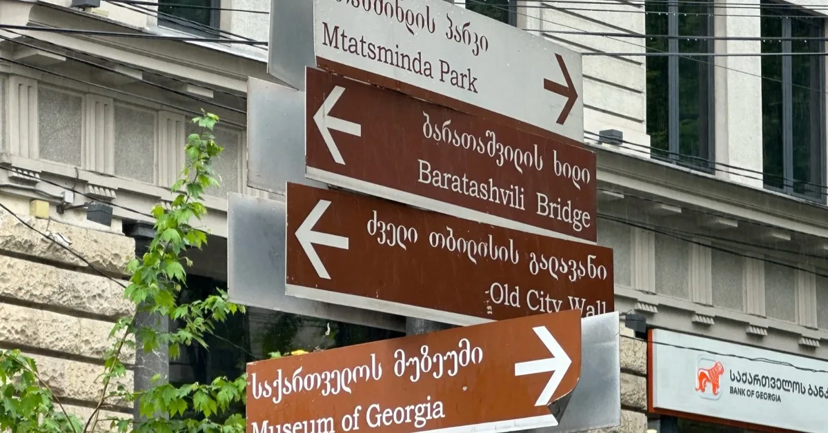 Sign posts in Tbilisi showing direction to main attractions in Georgian language and English.