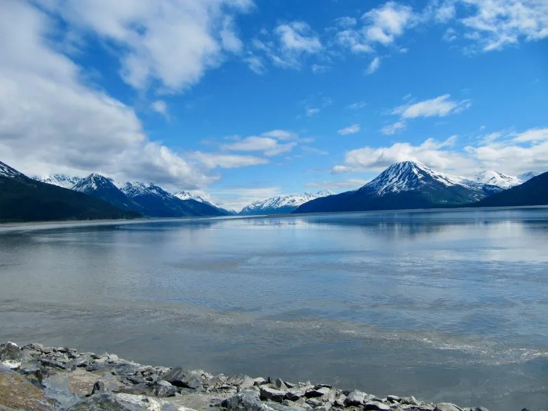 View of snow capped mountains with peaks reflecting in water in Alaska