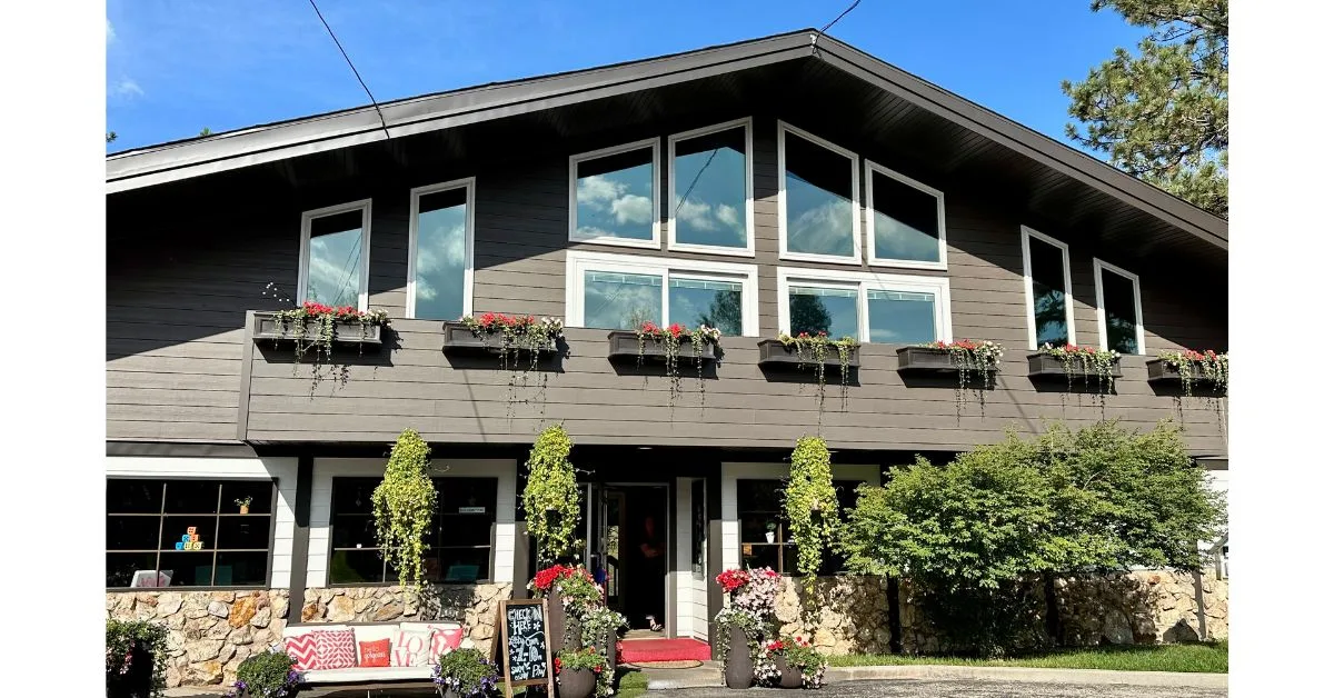 Alpine style slope roofed building with balcony and hanging flower baskets.