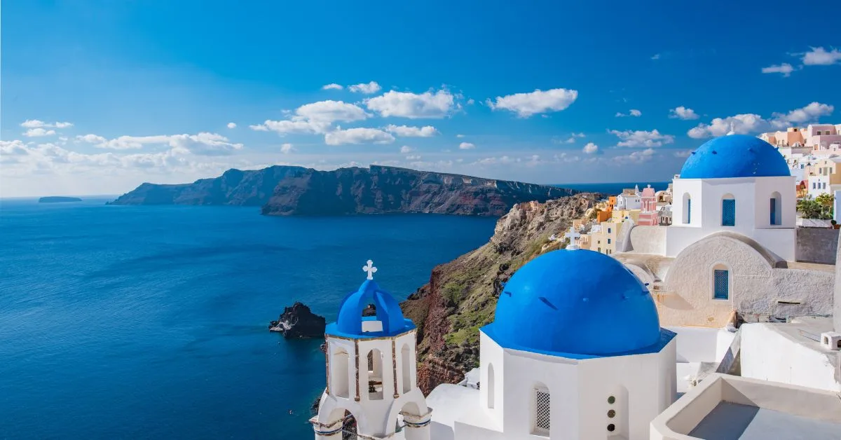White washed church with bright blue painted roofs on Santorini Island.
