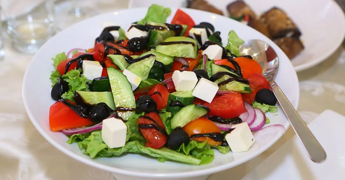 Greek salad with tomatoes, feta cheese, cucumber, onion and olives.